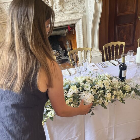 Wedding coordinator rearranging floral displays