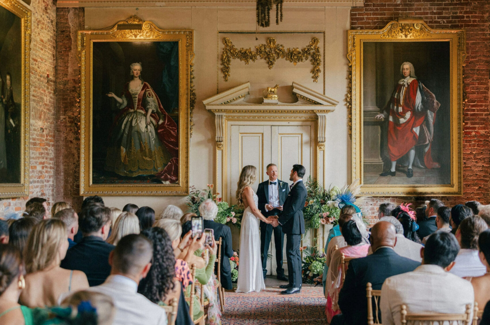 Couple exchanging vows during their wedding ceremony with guests seated around them.