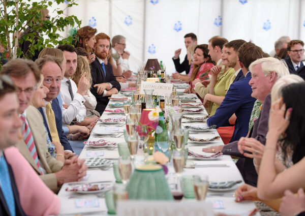 Wedding breakfast tables arranged with centrepieces, place settings and lamps ready for guests.