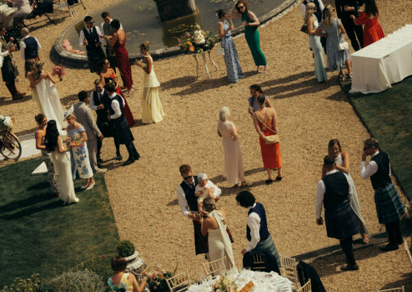 Wedding guests chatting and enjoying drinks during an outdoor wedding drinks reception.